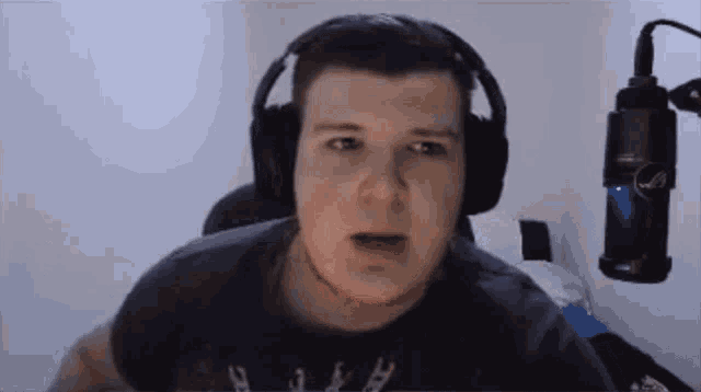 a man wearing headphones is sitting in front of a microphone