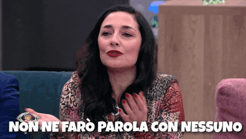 a woman sitting on a couch with the words " non ne faro parola con nessuno " behind her