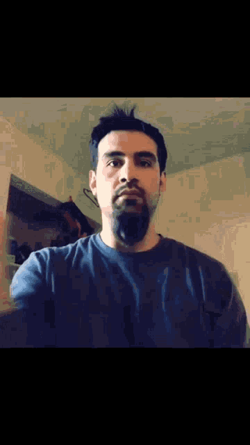 a man with a beard is wearing a black shirt that says ' abercrombie & fitch ' on the front