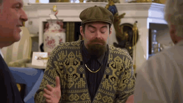 a man with a beard wearing a hat and a sweater with a pattern on it