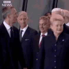a group of people standing next to each other with bbc news written on the bottom