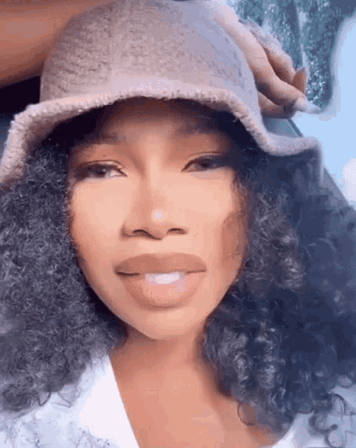 a close up of a woman wearing a bucket hat .