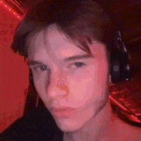 a young man wearing headphones is looking at the camera in a red room .