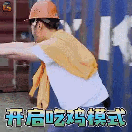 a man wearing a hard hat and a yellow scarf is standing in front of a blue wall .