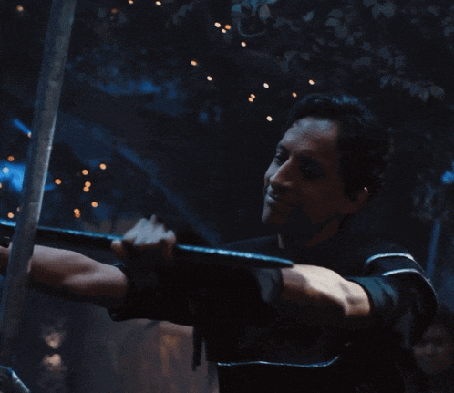 a man in a black shirt is holding a sword