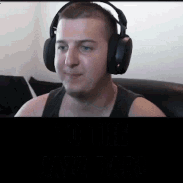 a man wearing headphones is sitting on a black couch