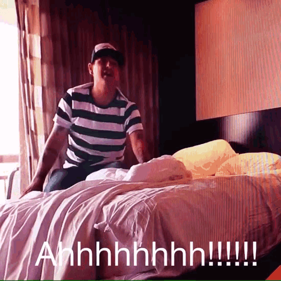 a man in a green and white striped shirt is sitting on a bed with the words ahhhh written below him