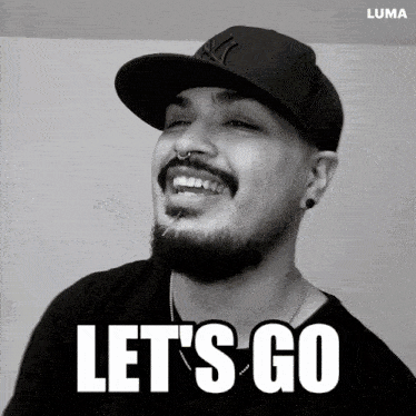a man with a beard wearing a new york yankees hat is smiling and says let 's go