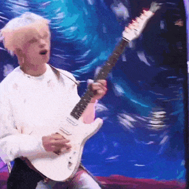 a man in a white shirt is playing a white electric guitar .