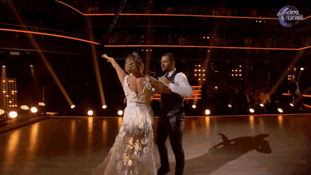a man and a woman are dancing on a stage with the words dancing brasil on the bottom