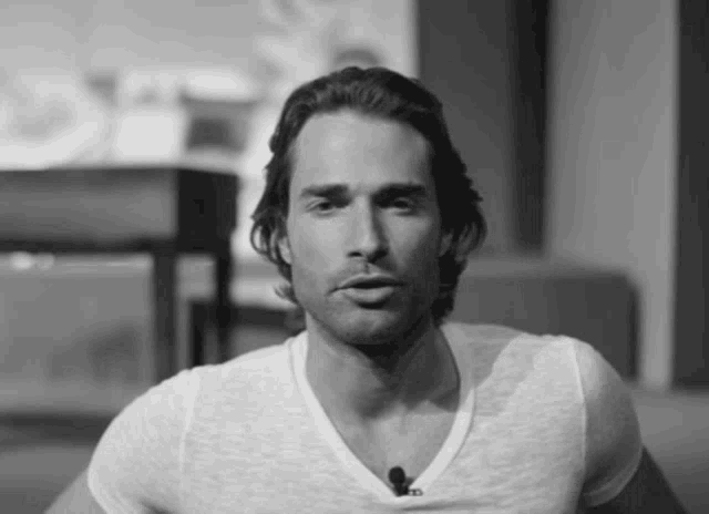 a black and white photo of a man wearing a white t-shirt and a microphone