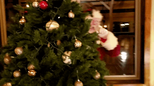 santa claus is standing in front of a christmas tree with decorations