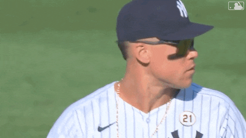 a baseball player wearing a hat and sunglasses is standing on a baseball field .