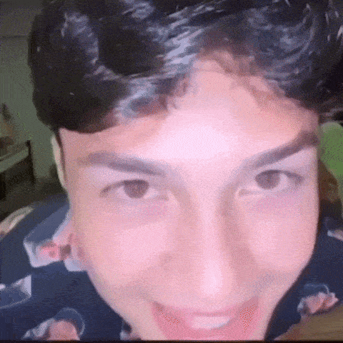 a close up of a young man 's face with his mouth open and his eyes closed .