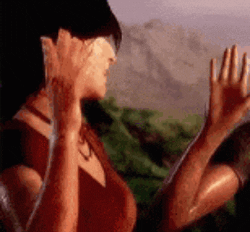 a woman in a red dress is covering her face with her hands .
