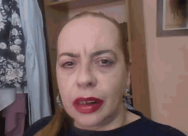 a woman with red lipstick on her lips is making a face