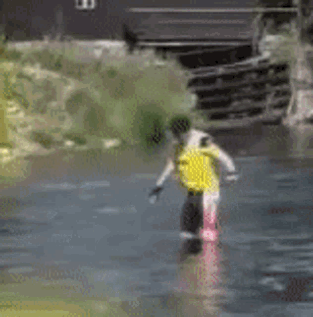 a person in a yellow shirt is standing in the water