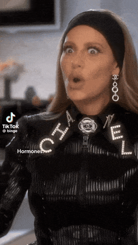 a woman wearing a chanel jacket and earrings