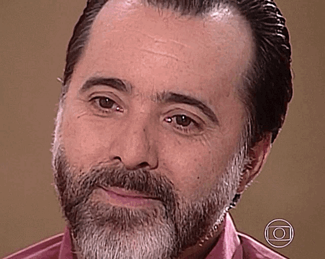 a man with a beard is wearing a pink shirt and has a circle around his face