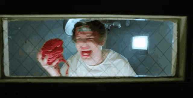 a man in a white shirt is holding a piece of meat in his hand