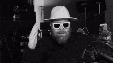 a man with a beard wearing a white hat and white sunglasses