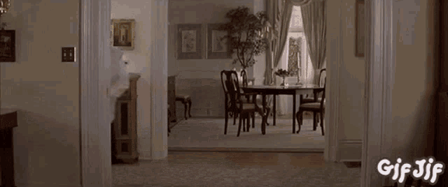 a gif of a man dancing in a room with the words gif jif on the bottom
