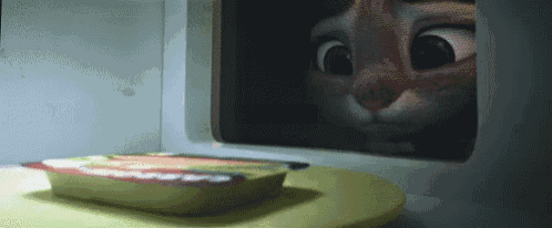 a cartoon cat is looking out of a microwave .