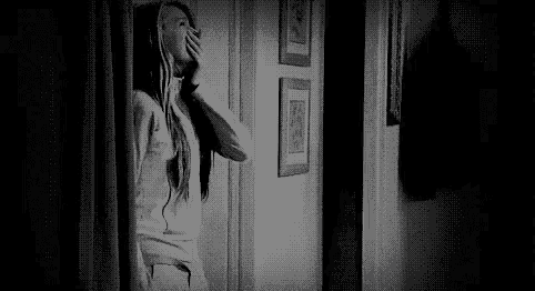 a black and white photo of a woman in a doorway .