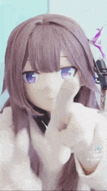 a doll with purple hair and blue eyes is making a funny face and pointing at the camera .