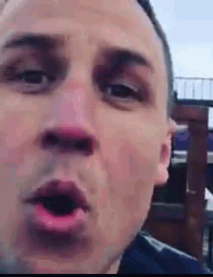 a close up of a man 's face with his mouth open and his eyes closed