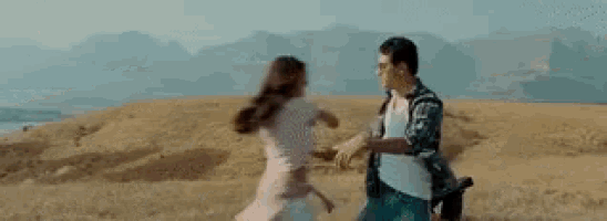 a man and a woman are dancing in a field .