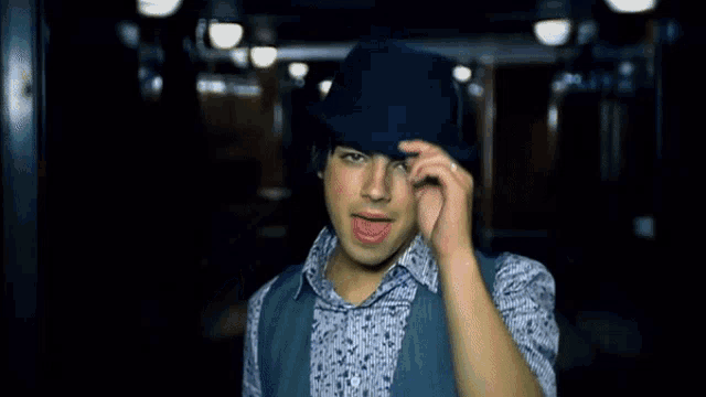 a young man wearing a black hat and a blue shirt