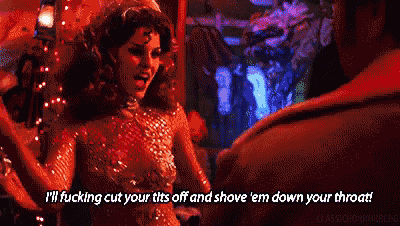 a woman in a red dress is talking to a man in a club and says i 'll fucking cut your tits off
