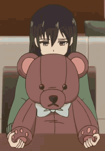 a girl holding a teddy bear with a bow tie