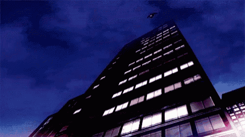 a person is flying over a tall building at night .