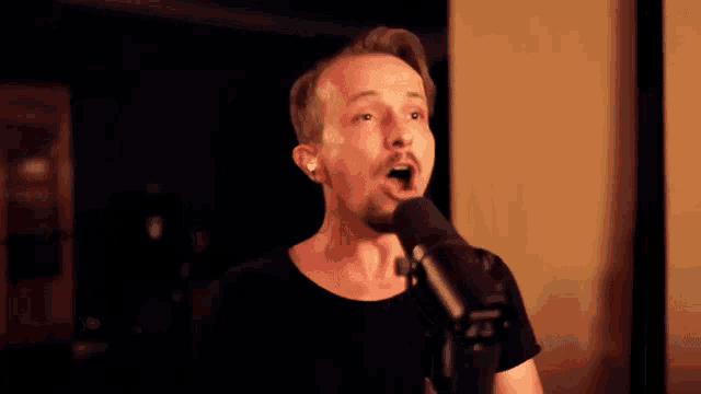 a man singing into a shure microphone while wearing earbuds