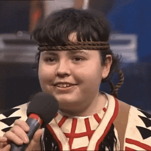 a young girl wearing a headband is singing into a microphone ..