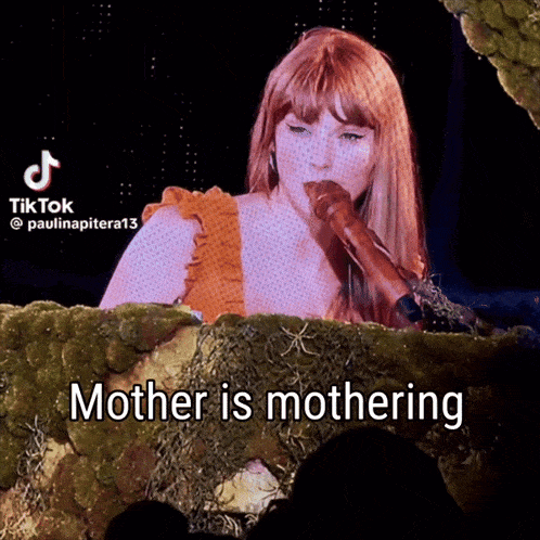 a woman singing into a microphone with the words mother is mothering