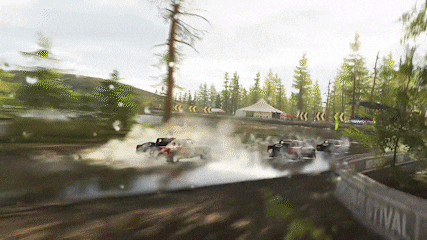 a group of cars are driving down a dirt road with trees in the background