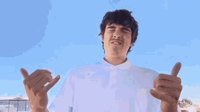 a man in a white shirt is holding his head in his hands