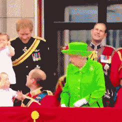 queen elizabeth wearing a green hat is standing in front of a crowd