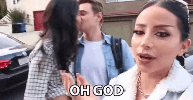 a man is kissing a woman on the cheek while a woman talks to him .