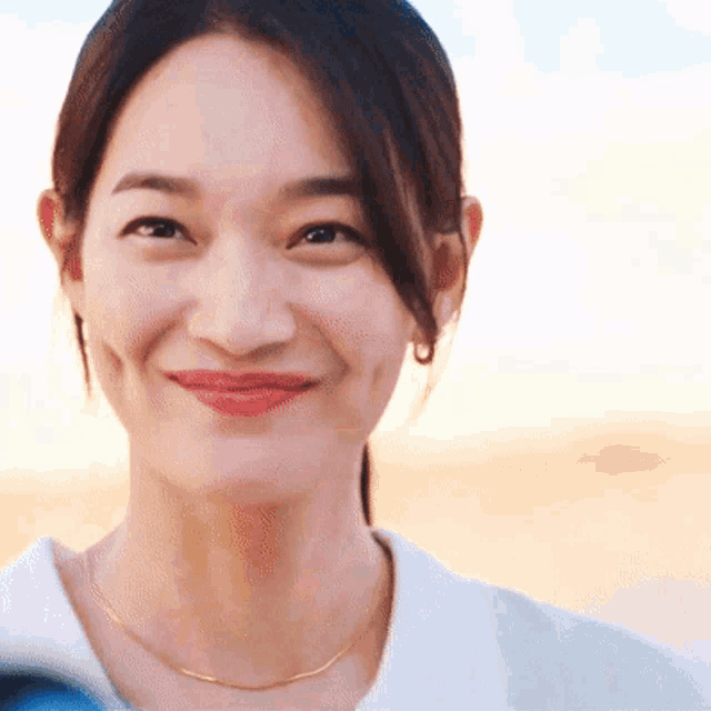 a close up of a woman 's face with a smile