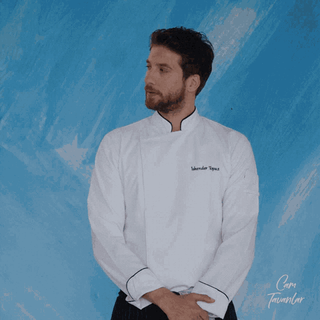 a man wearing a white chef 's jacket with the name iskender topuz