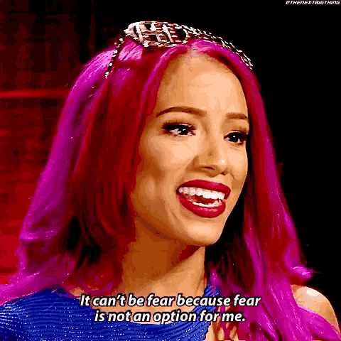 a woman with purple hair is smiling and saying it can 't be fear because fear is not an option for me