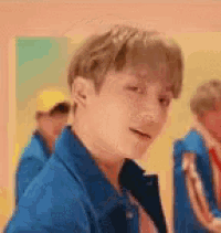 a man in a blue jacket is standing in front of a mirror .