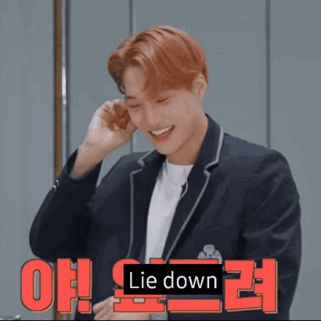 a young man in a suit is smiling with the words lie down written above him
