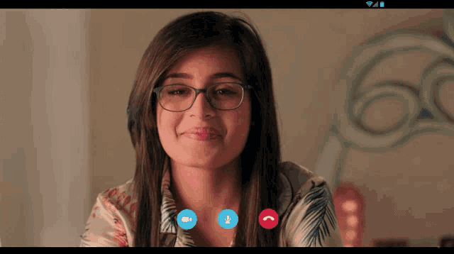 a woman wearing glasses has a video call on her phone