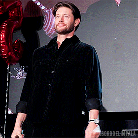 a man in a black shirt is standing in front of balloons with the word impala on the bottom right