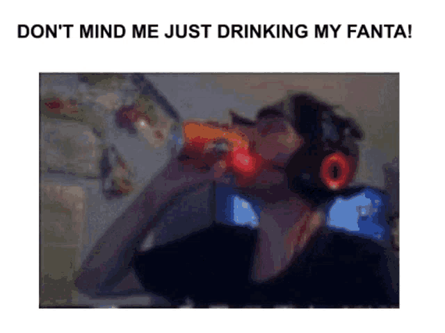 a man wearing headphones is drinking a bottle of fanta